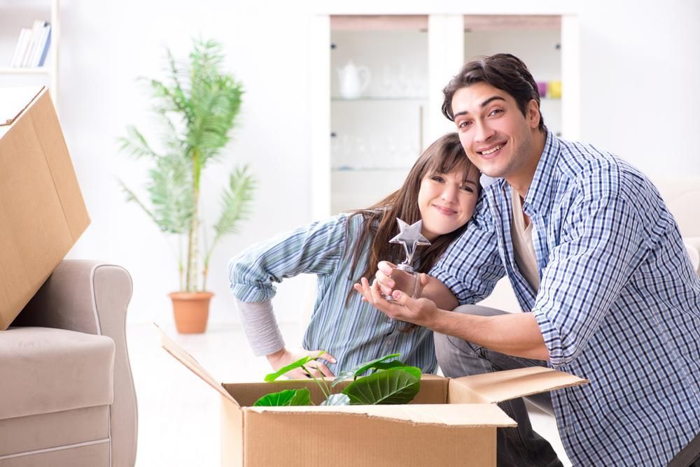 A Man And A Woman Are Moving Into A New Home — Howells & Co Legal & Conveyancing In Cessnock, NSW