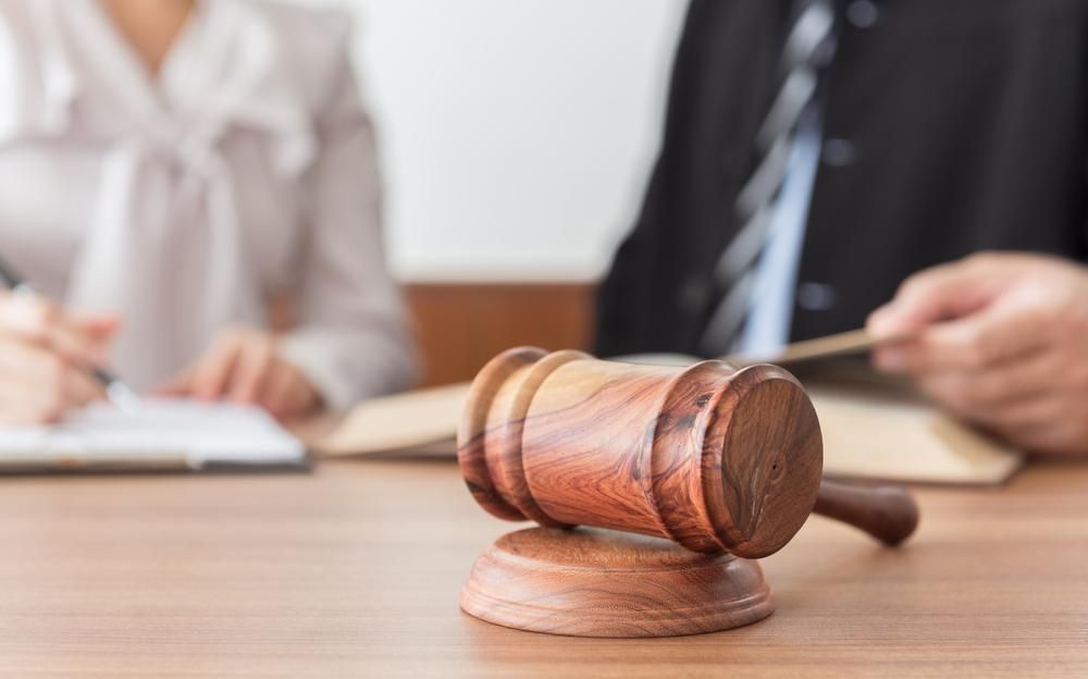A Judge 's Gavel Is Sitting On A Wooden Table — Howells & Co Legal & Conveyancing In Newcastle, NSW