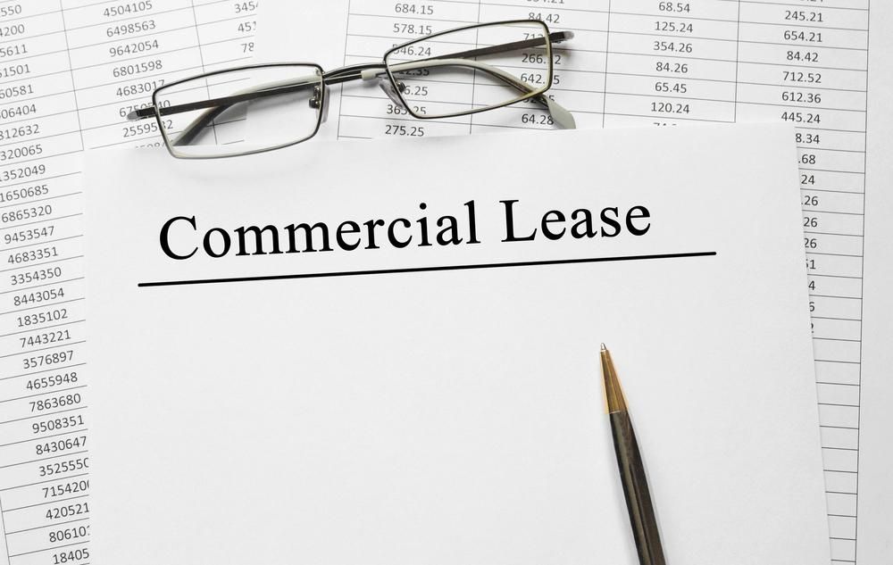 A Pair Of Glasses Is Sitting On Top Of A Piece Of Paper That Says Commercial Lease — Howells & Co Legal & Conveyancing In Sydney, NSW