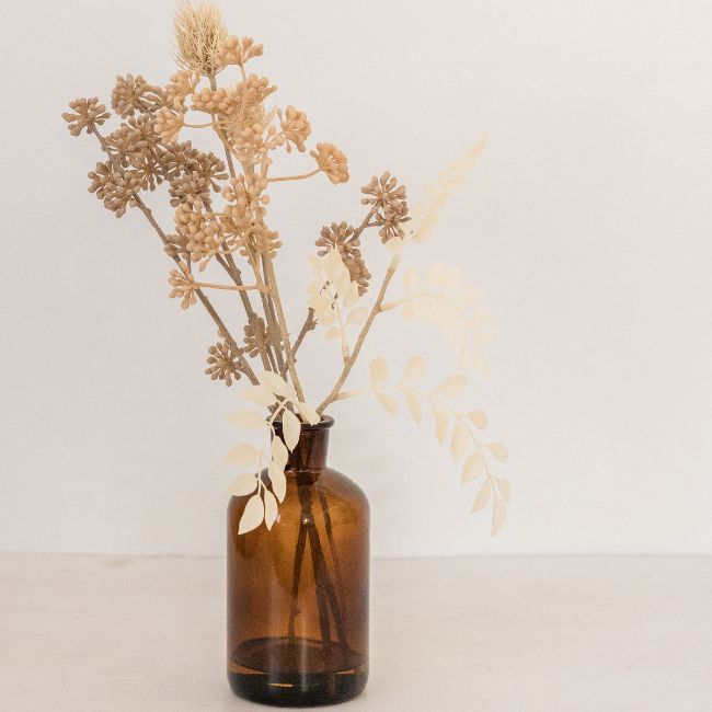 A Brown Glass Vase With Dried Flowers In It — Howells & Co Legal & Conveyancing In Cessnock, NSW