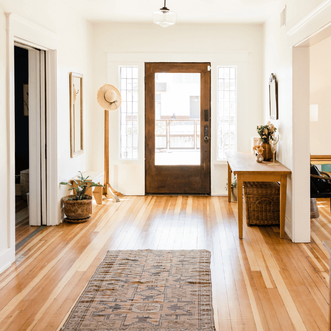 A Hallway With Hardwood Floors And A Rug In The Middle — Howells & Co Legal & Conveyancing In Cessnock, NSW