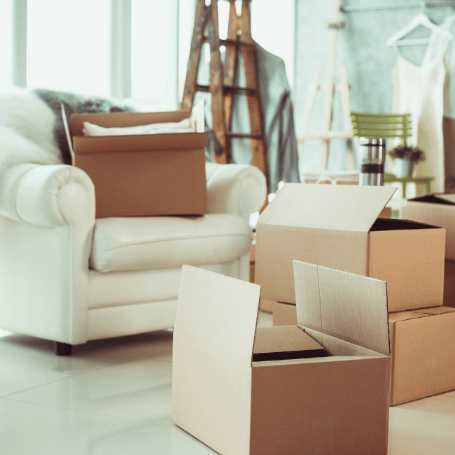 Cardboard Boxes Are Stacked On Top Of Each Other In A Living Room — Howells & Co Legal & Conveyancing In Cessnock, NSW