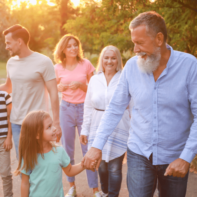 A Group Of People Are Walking Down A Street Holding Hands — Howells & Co Legal & Conveyancing In Cessnock, NSW