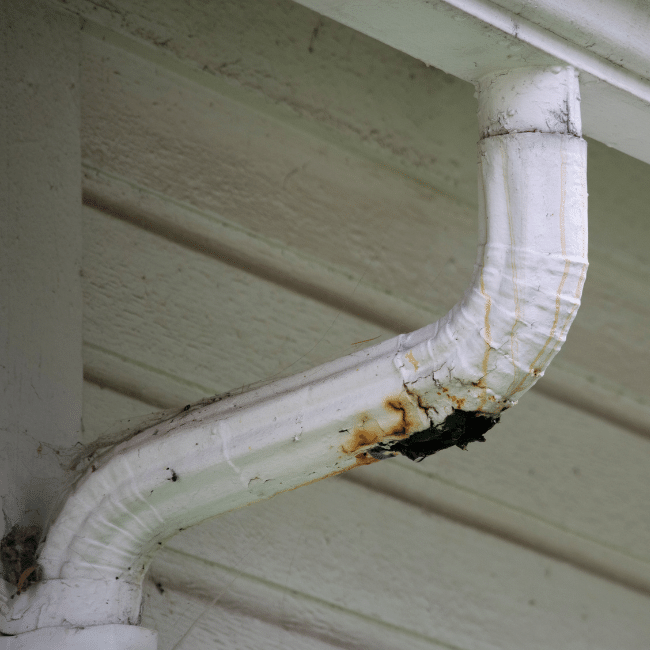 A White Gutter With Rust On It Is Hanging From The Ceiling Of A House — Howells & Co Legal & Conveyancing In Cessnock, NSW