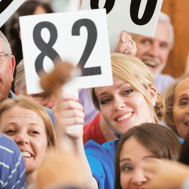 A Group Of People Holding Up Signs With The Number 82 On Them — Howells & Co Legal & Conveyancing In Cessnock, NSW