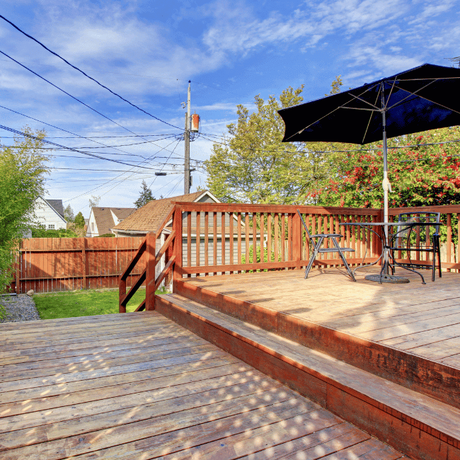 A Wooden Deck With A Table And Chairs And An Umbrella — Howells & Co Legal & Conveyancing In Cessnock, NSW