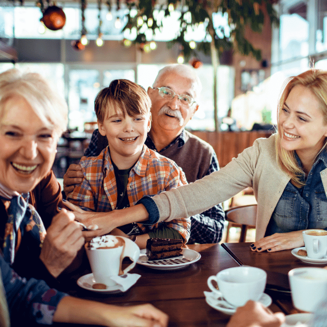 A Group Of People Are Sitting At A Table Eating Food And Drinking Coffee — Howells & Co Legal & Conveyancing In Cessnock, NSW