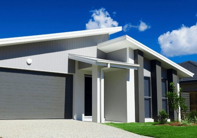 A White House With A Gray Garage Door And A Blue Sky In The Background — Howells & Co Legal & Conveyancing In Cessnock, NSW