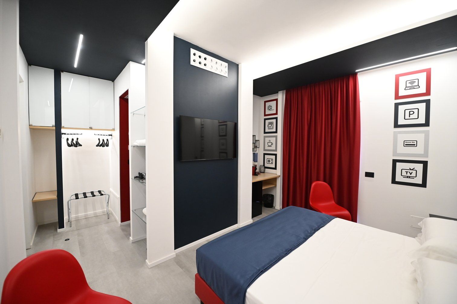 Una stanza d'albergo con un letto, sedie e una televisione