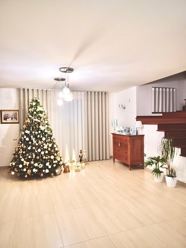 Un soggiorno con un albero di Natale e scale