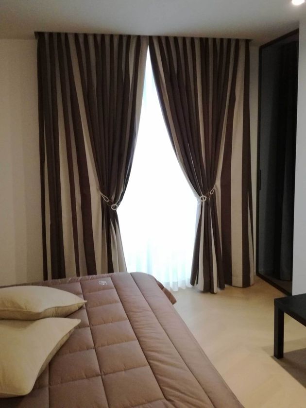 Una camera da letto con un letto e tende a strisce