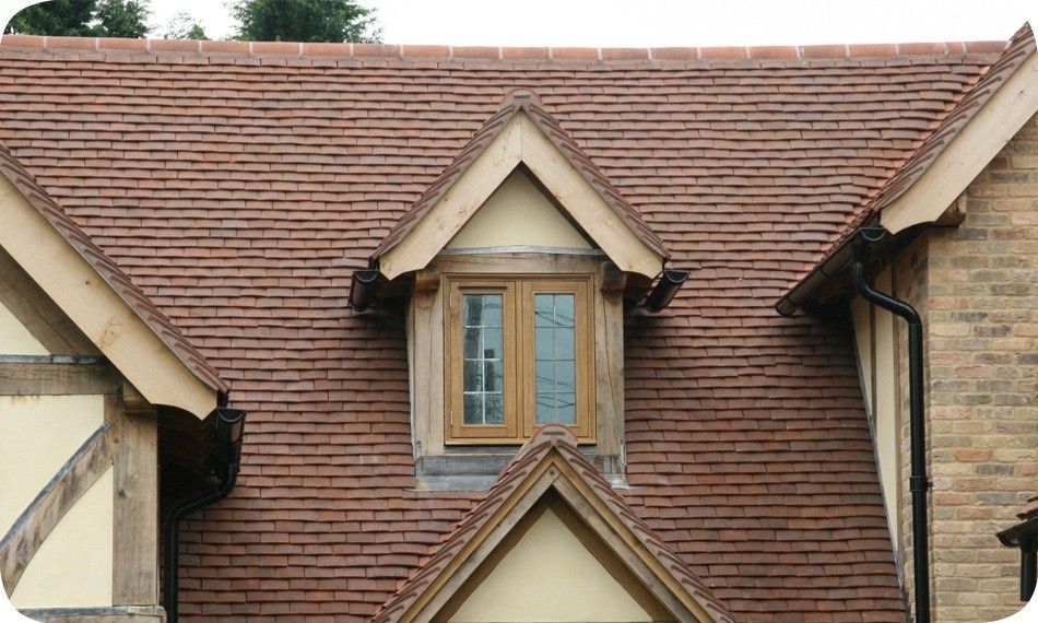 Clay tile roof with a dormer window. The window is surrounded by light wood trim.