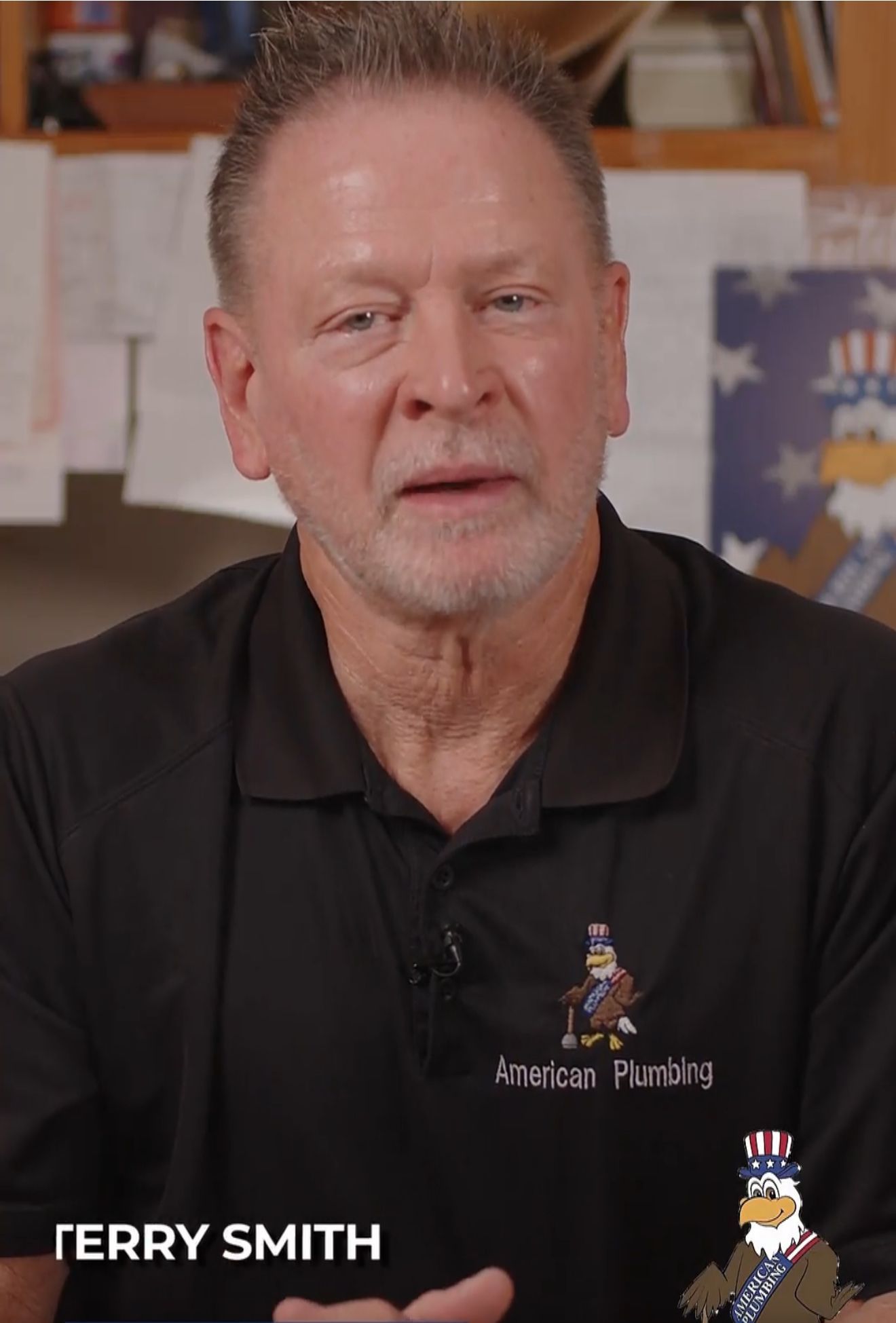 Man in a black polo shirt speaking indoors, with the name “TERRY SMITH” on screen.