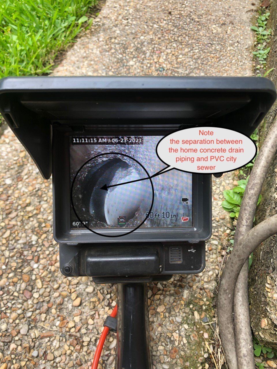 A black outdoor camera showing a pipe with a separator. The text notes