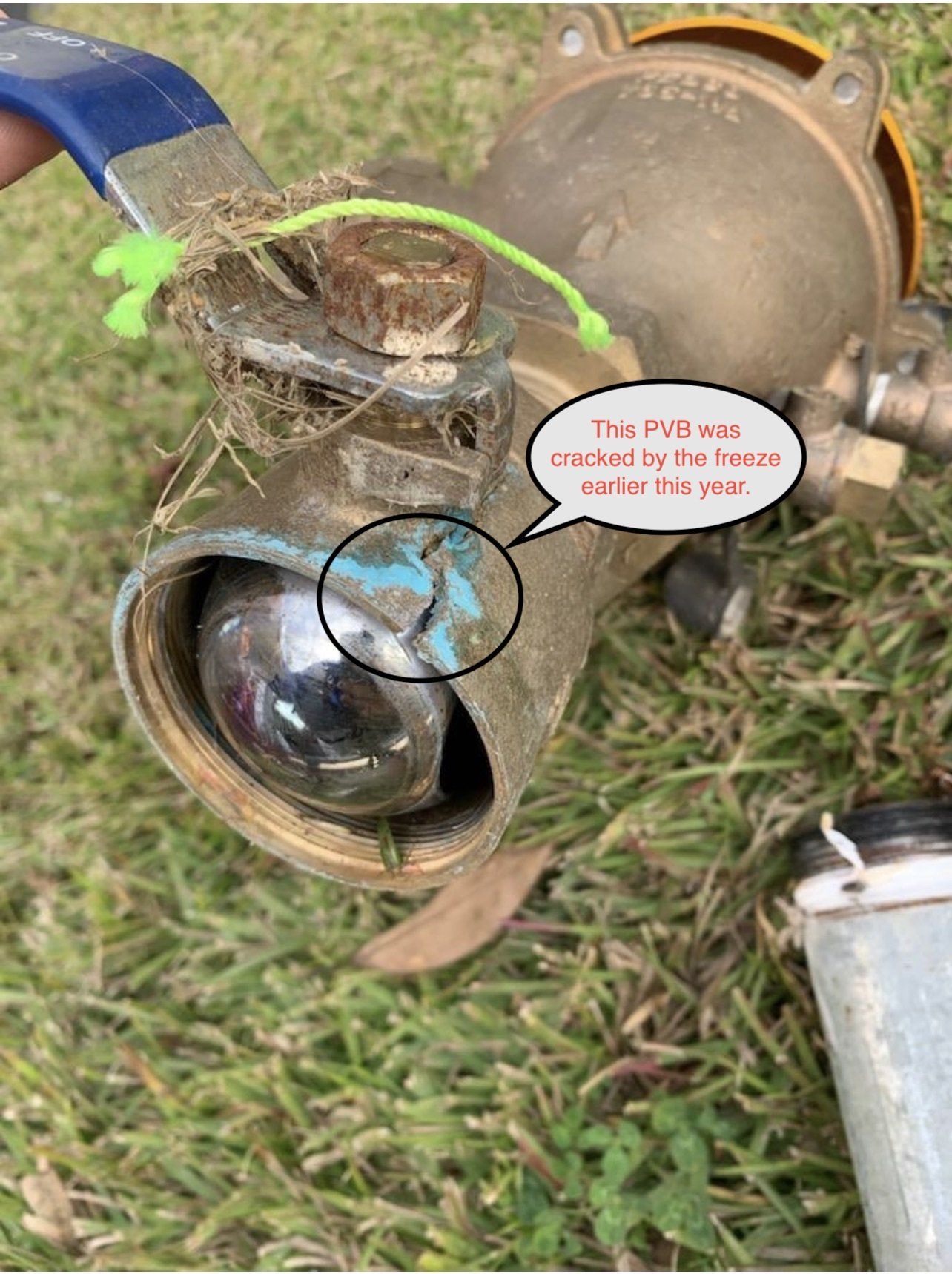 Damaged water valve with a crack, on grass.