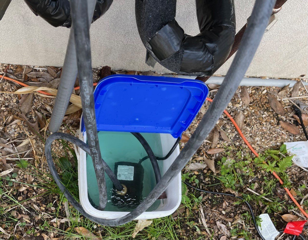Blue utility box with cables and a meter inside a small ground enclosure outdoors