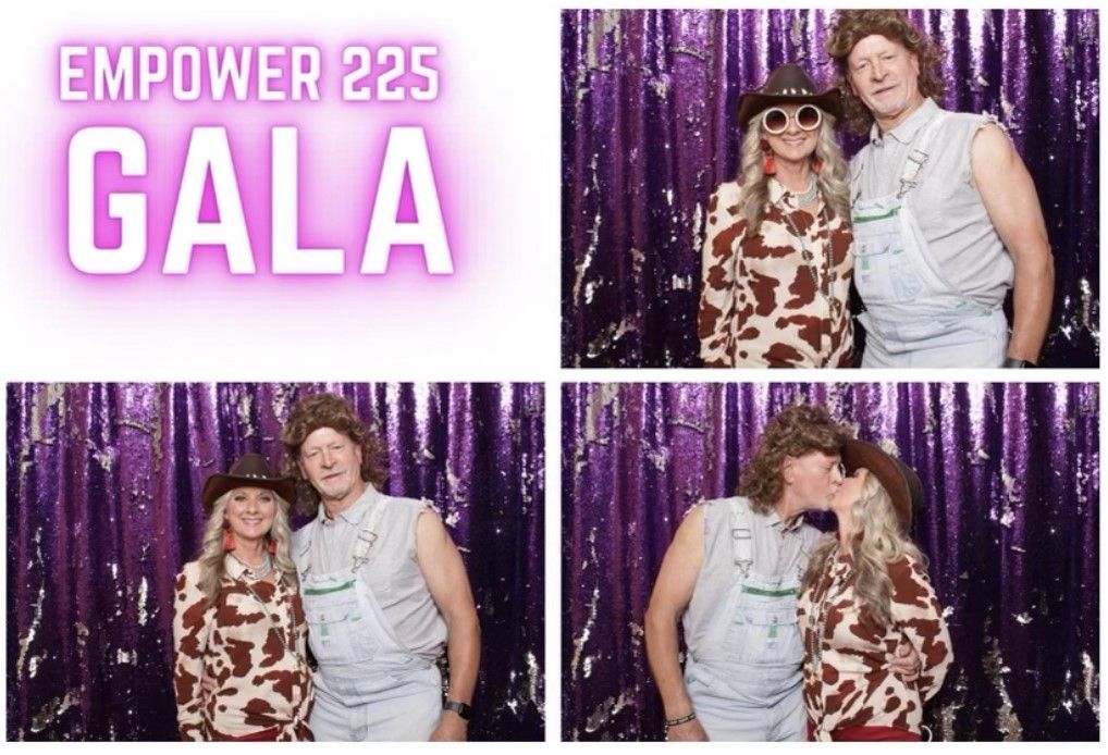 Empower 225 Gala: Couple in cow-print outfit and overalls pose in a photo booth with purple backdrop.