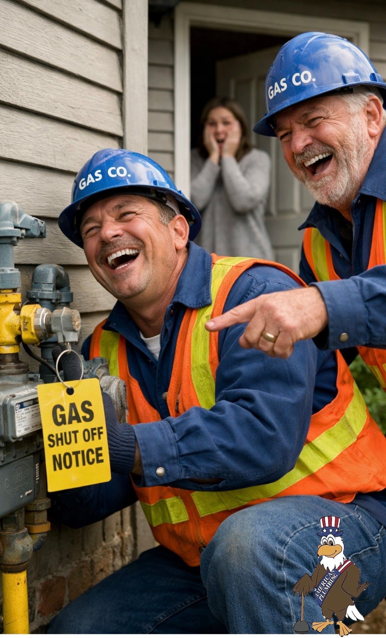 Two utility workers in blue hard hats inspect a gas shutoff valve, one smiling and pointing, outside a house