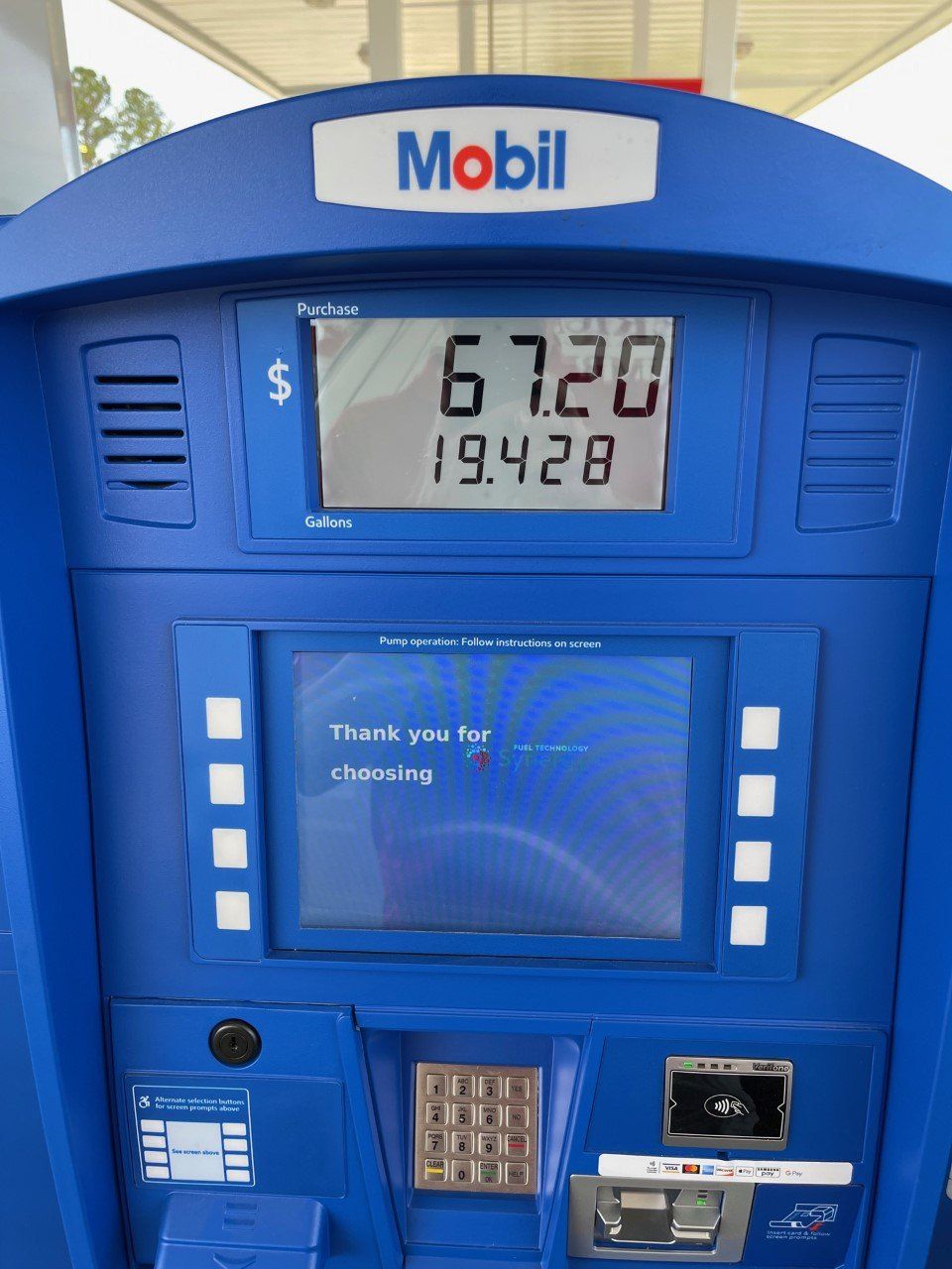 Blue Mobil gas pump display showing $67.20 and 19.428 gallons purchased