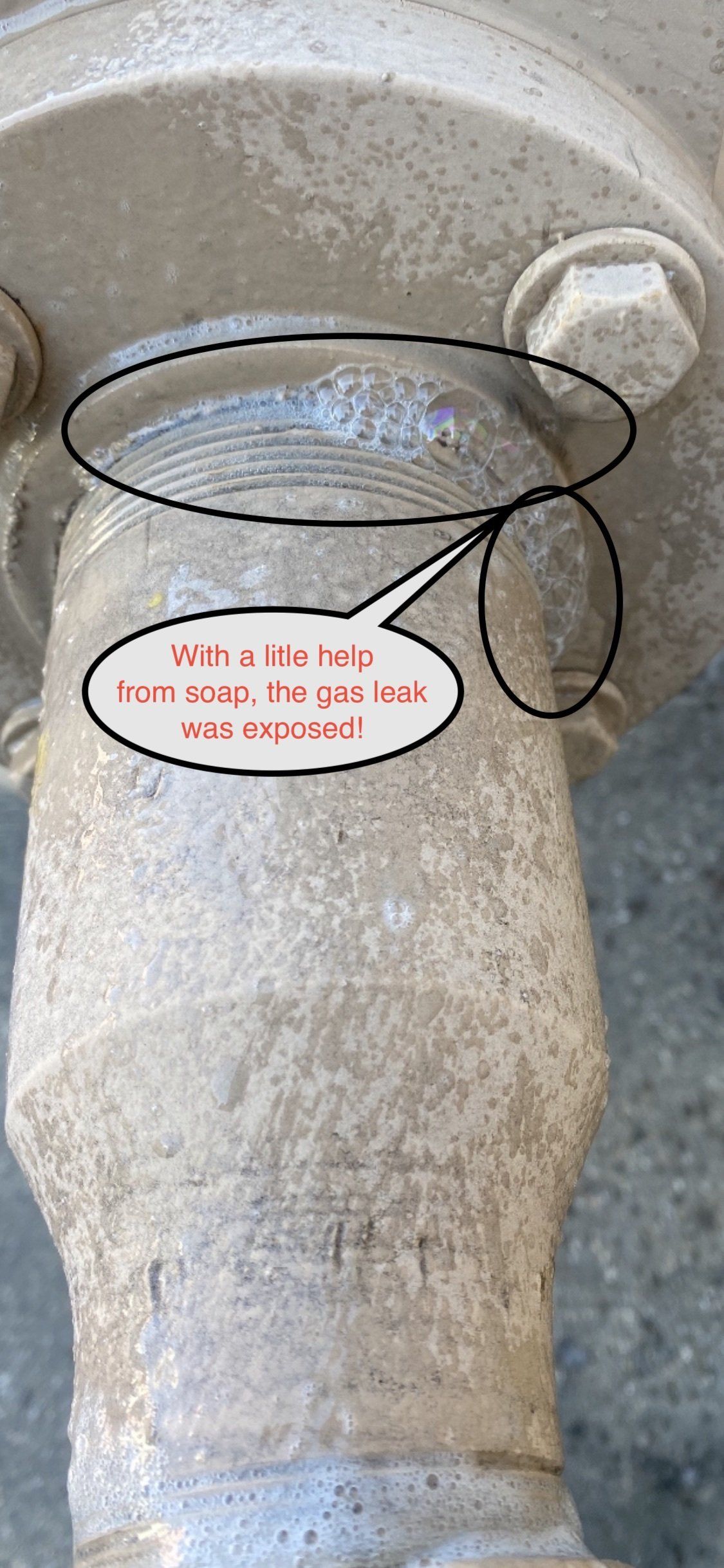 Stone statue close-up with black hand-drawn circles highlighting the top and a red text label