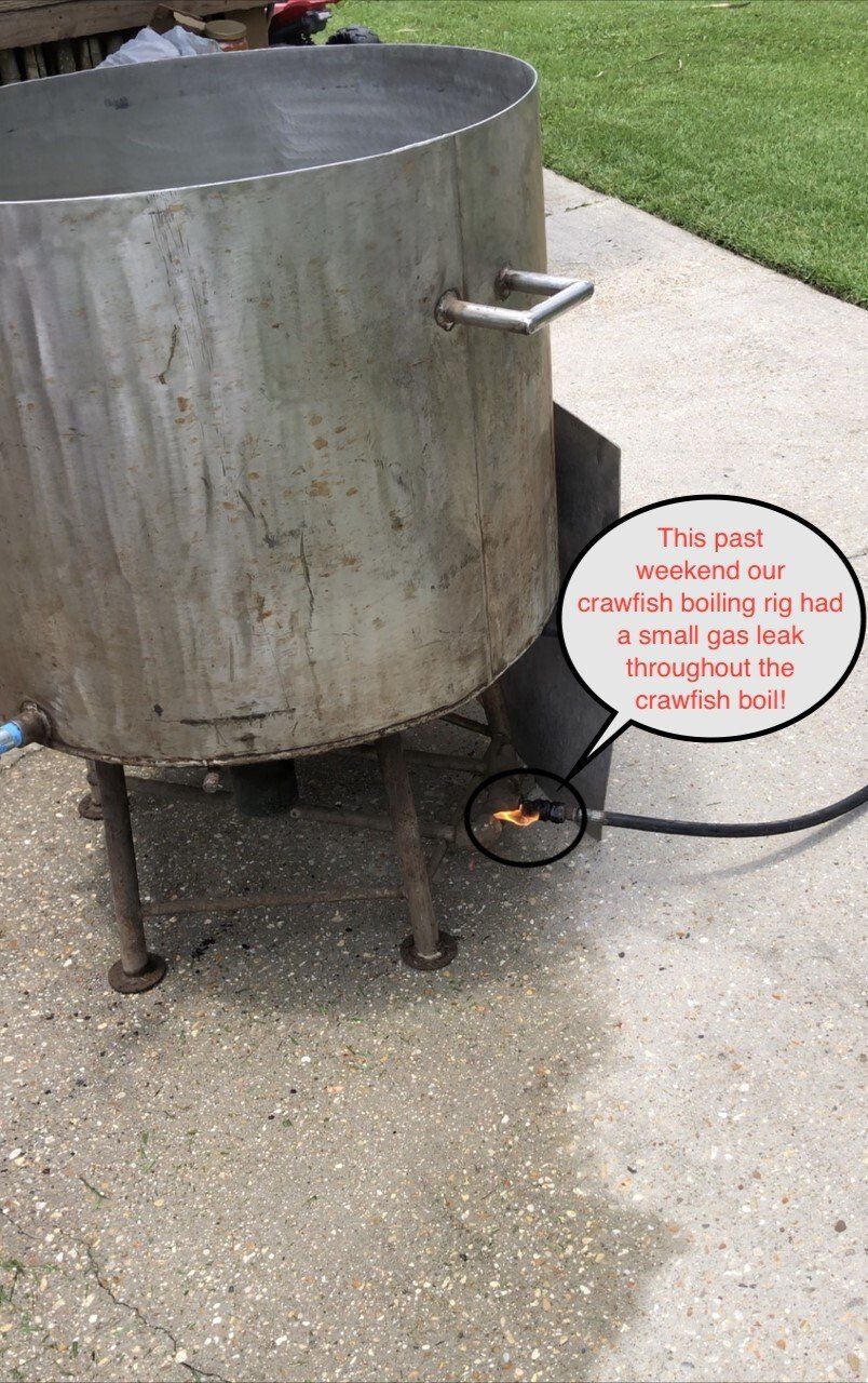 Large metal pot on legs, gas burner, used for boiling food outdoors.