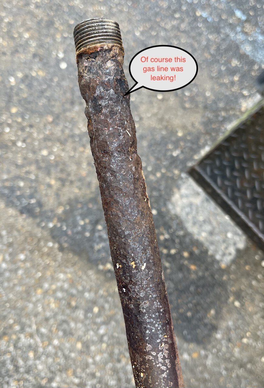 Rusty metal rod with threaded end on concrete pavement
