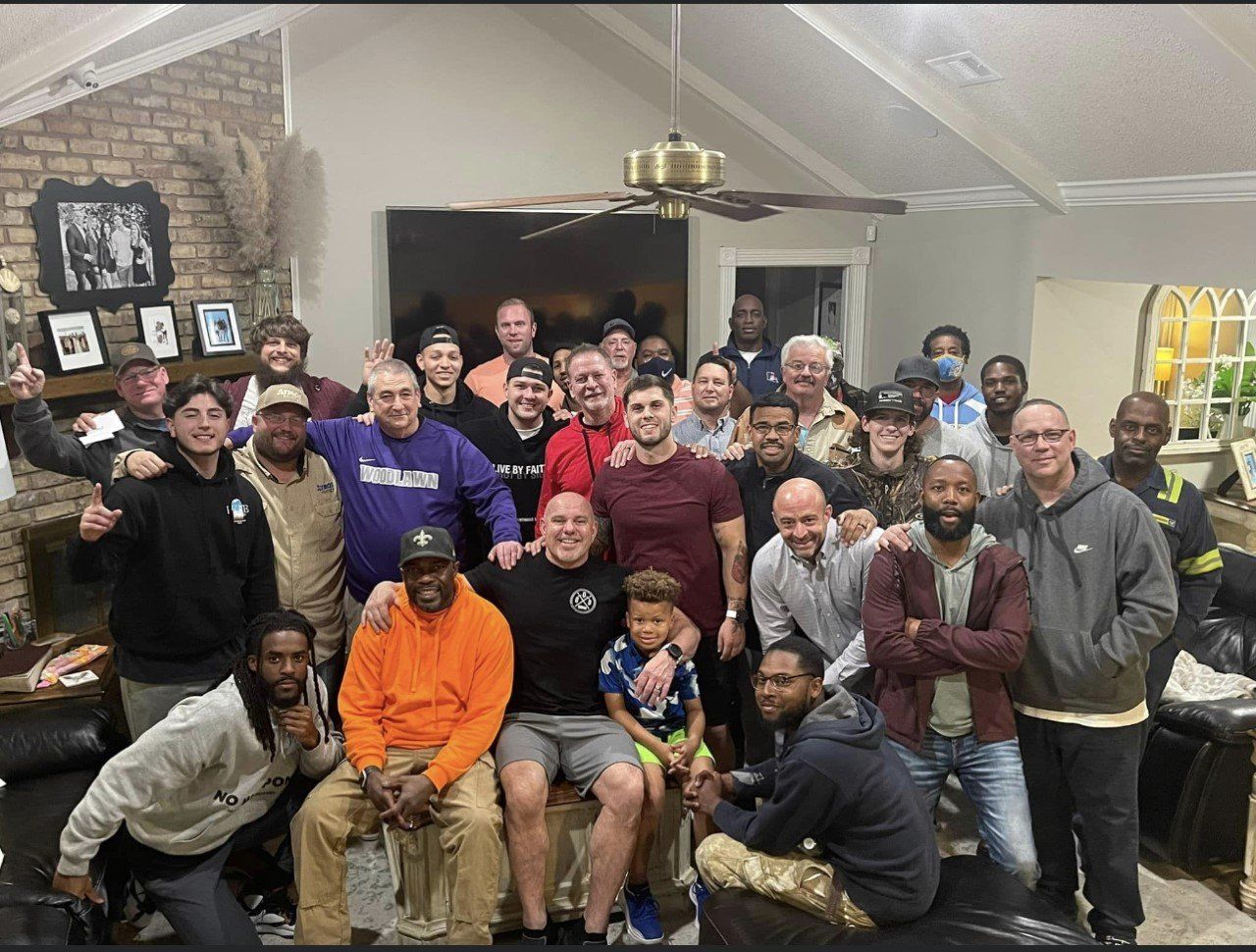 Large group of diverse people smiling and posing indoors. Some are seated, others standing.