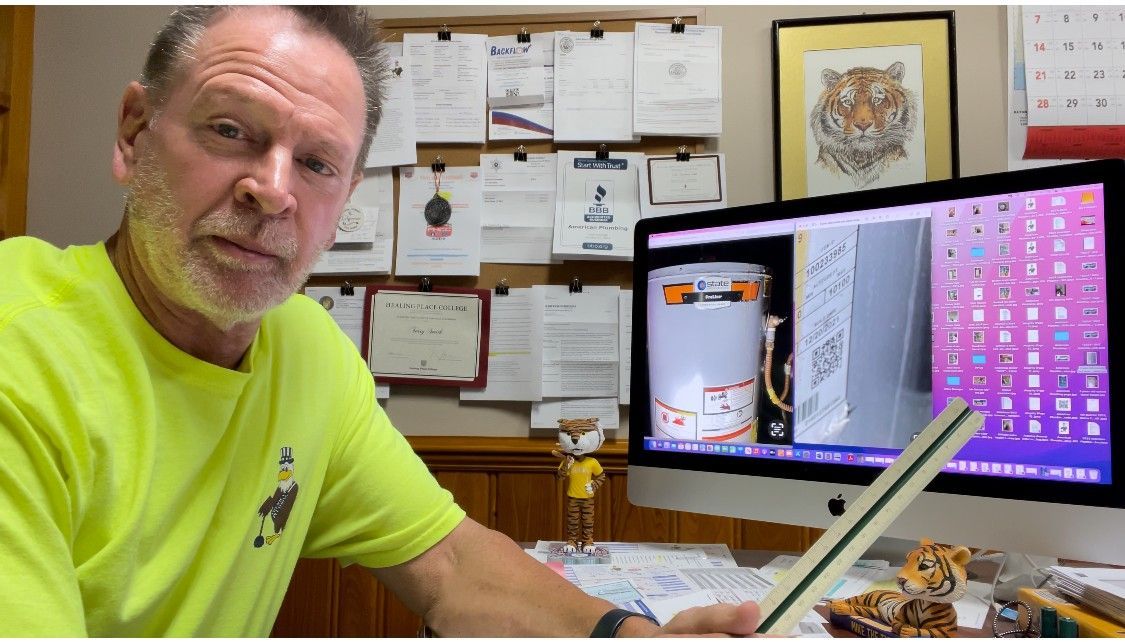 Man in neon shirt, looking at the camera, with a computer screen showing a product photo.