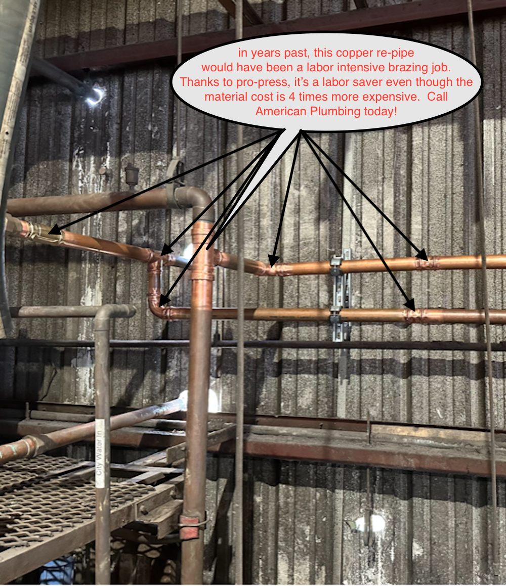 Industrial scaffolding and rusted pipes against a corrugated metal wall, with a white sign overhead.