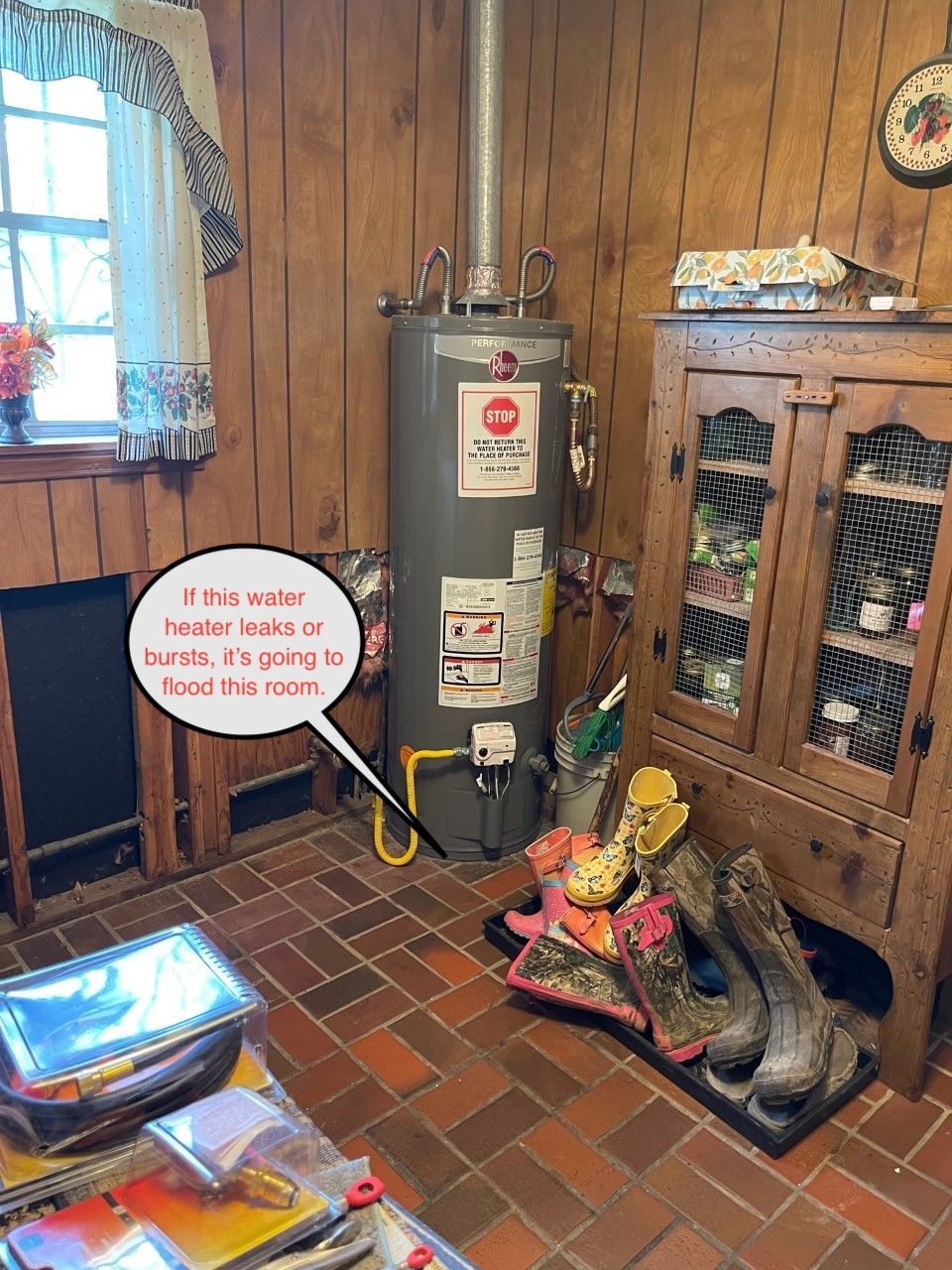Basement utility room with furnace, wood paneling, brick floor, and decorative boots by a cabinet.