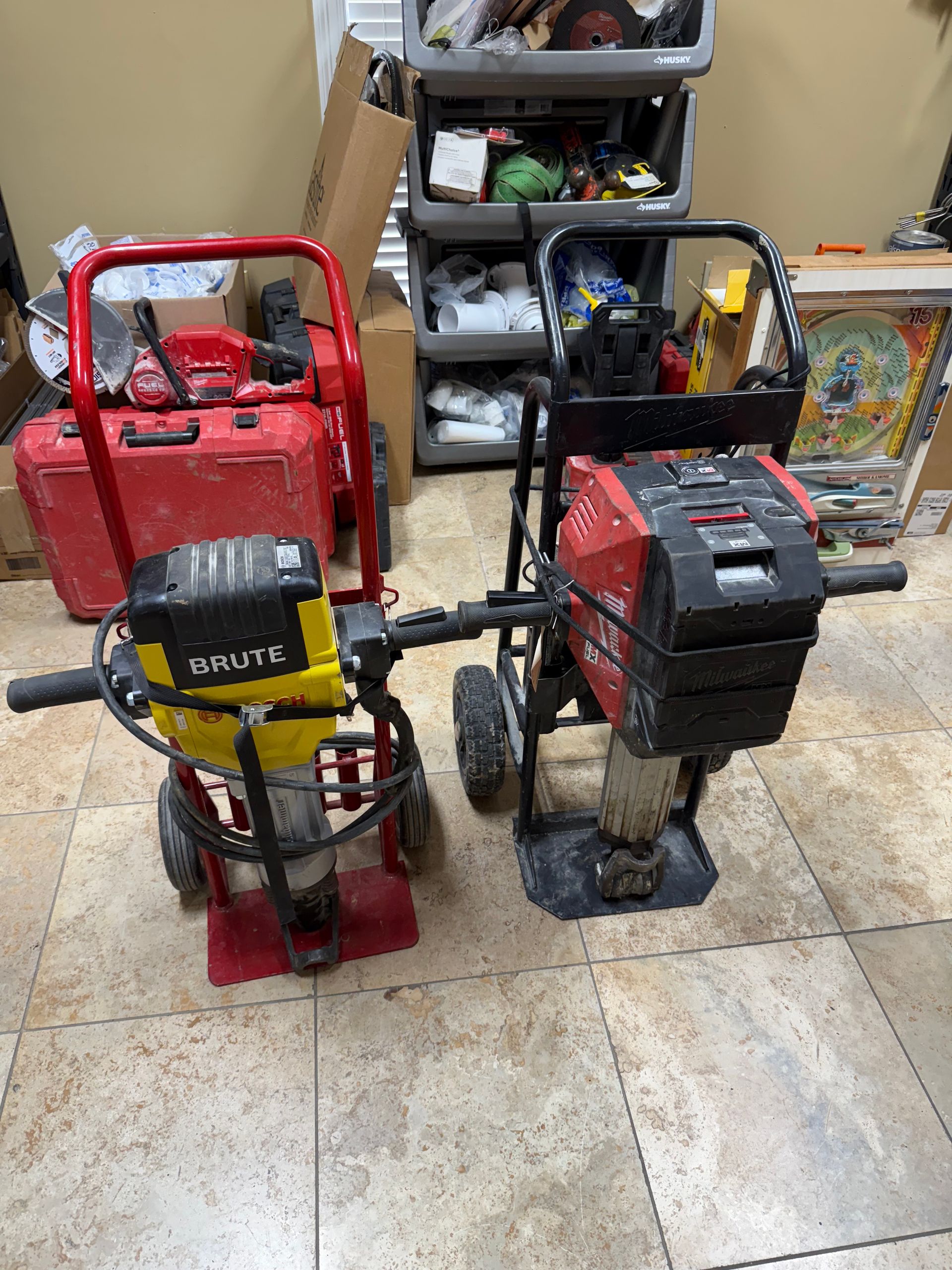 Two small red-and-black utility carts on a tiled floor beside a storage shelf