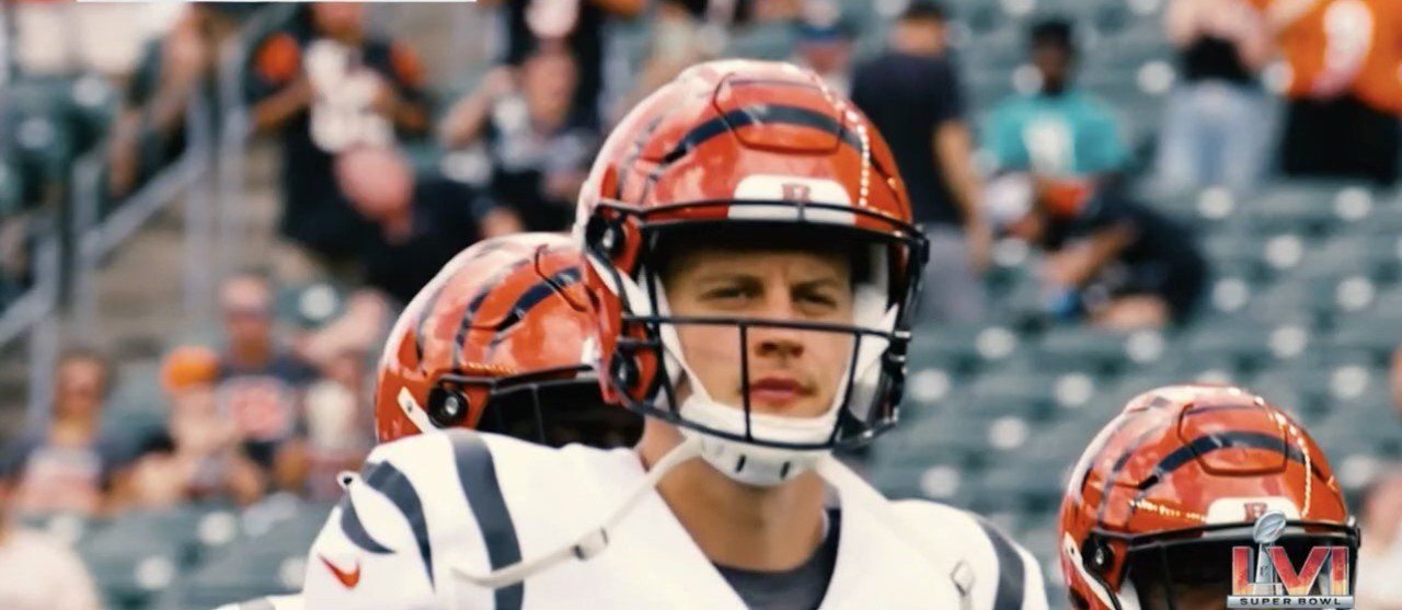 Football players in orange helmets and white jerseys standing on the field