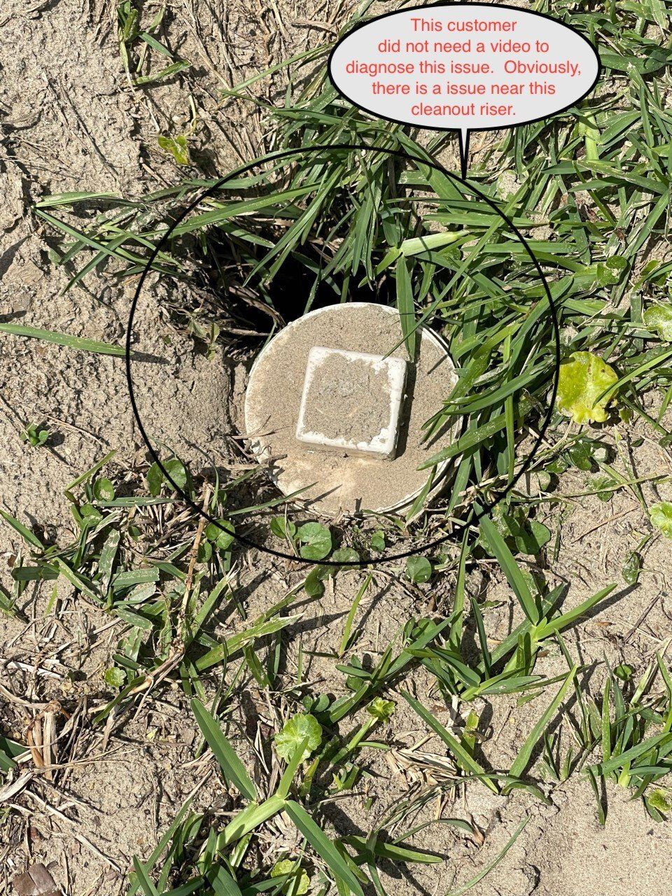 A hole in the ground with a concrete cap, surrounded by grass and dirt. Text says,