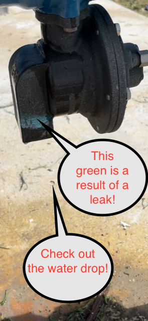 A water pump with green corrosion, indicating a leak. A water drop is also visible.