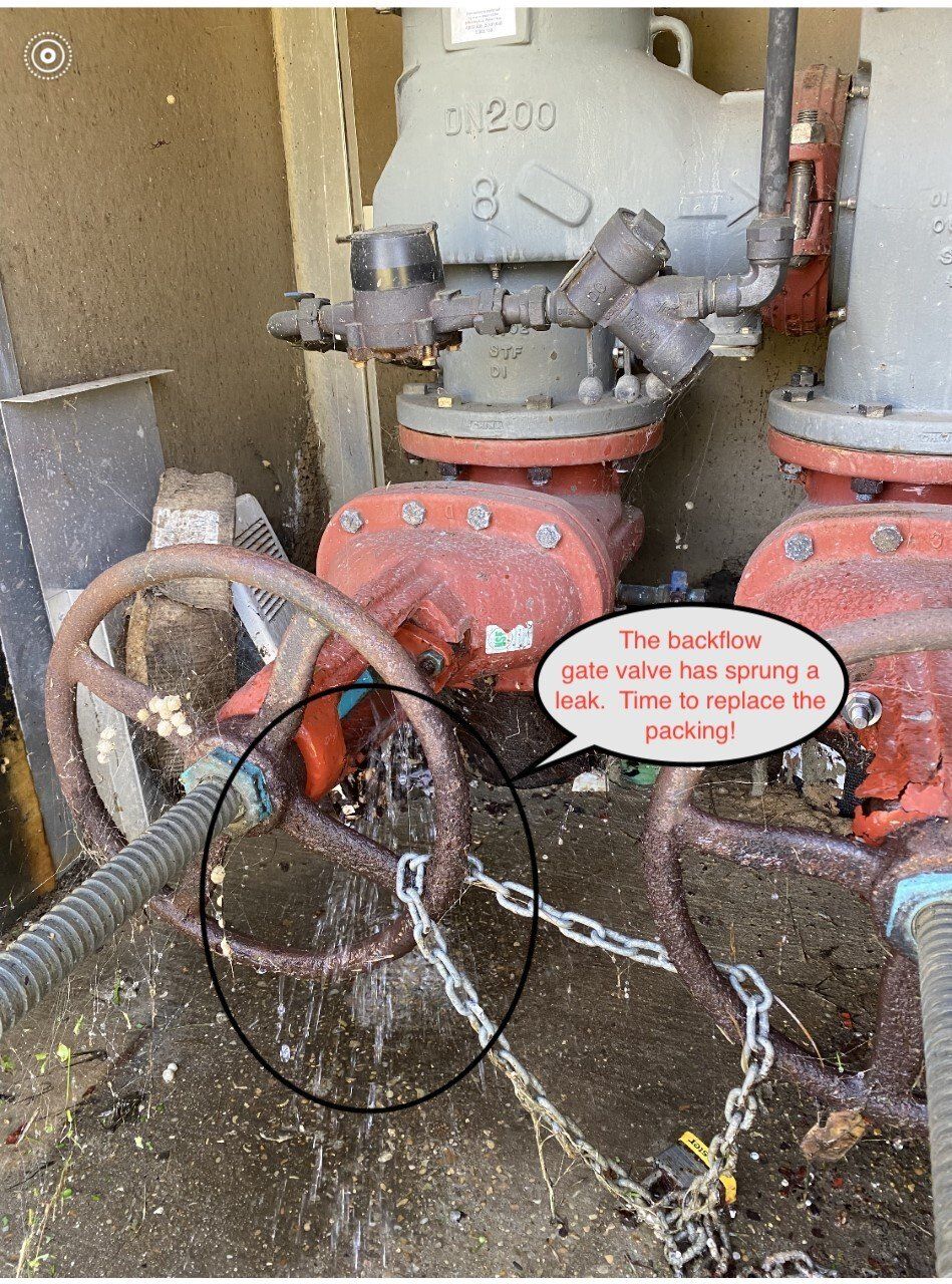 A water valve is leaking. The rusted handle is chained. A note says 