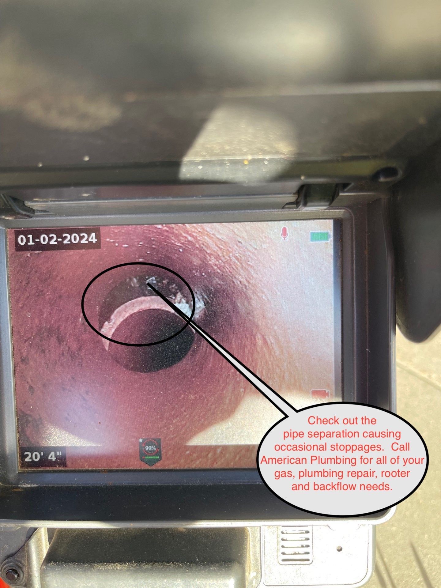 Close-up of a monitor showing a circular spot on pink tissue, circled in black with an arrow and note.