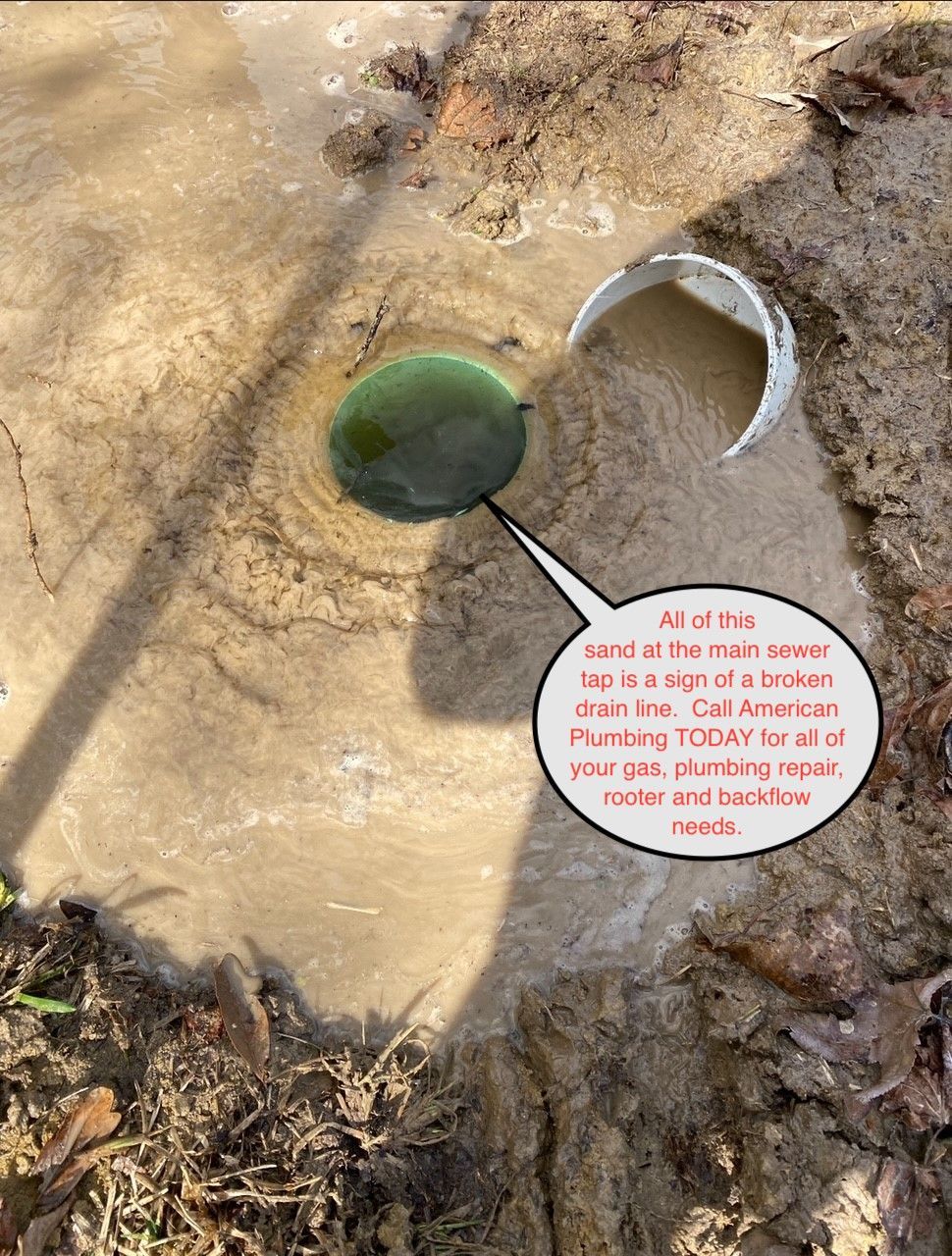 Muddy ground with a sewer cover and broken pipe, likely a drain issue.