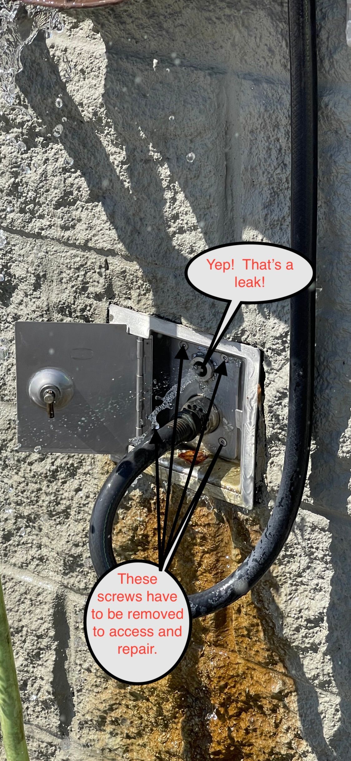 Close-up of a wall-mounted box with black cable and two red-and-white warning labels.