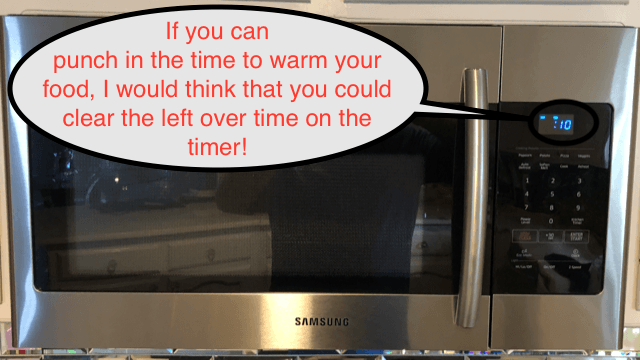 Stainless steel microwave with a reminder bubble about punching in time to warm food.