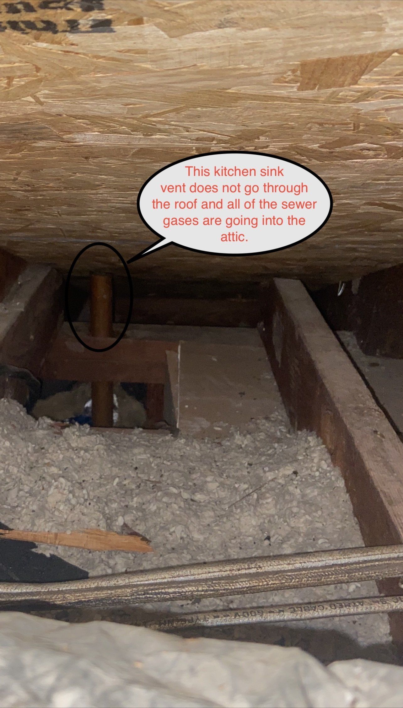 Wooden plumbing pipe in an attic, with handwritten text bubble pointing to it.