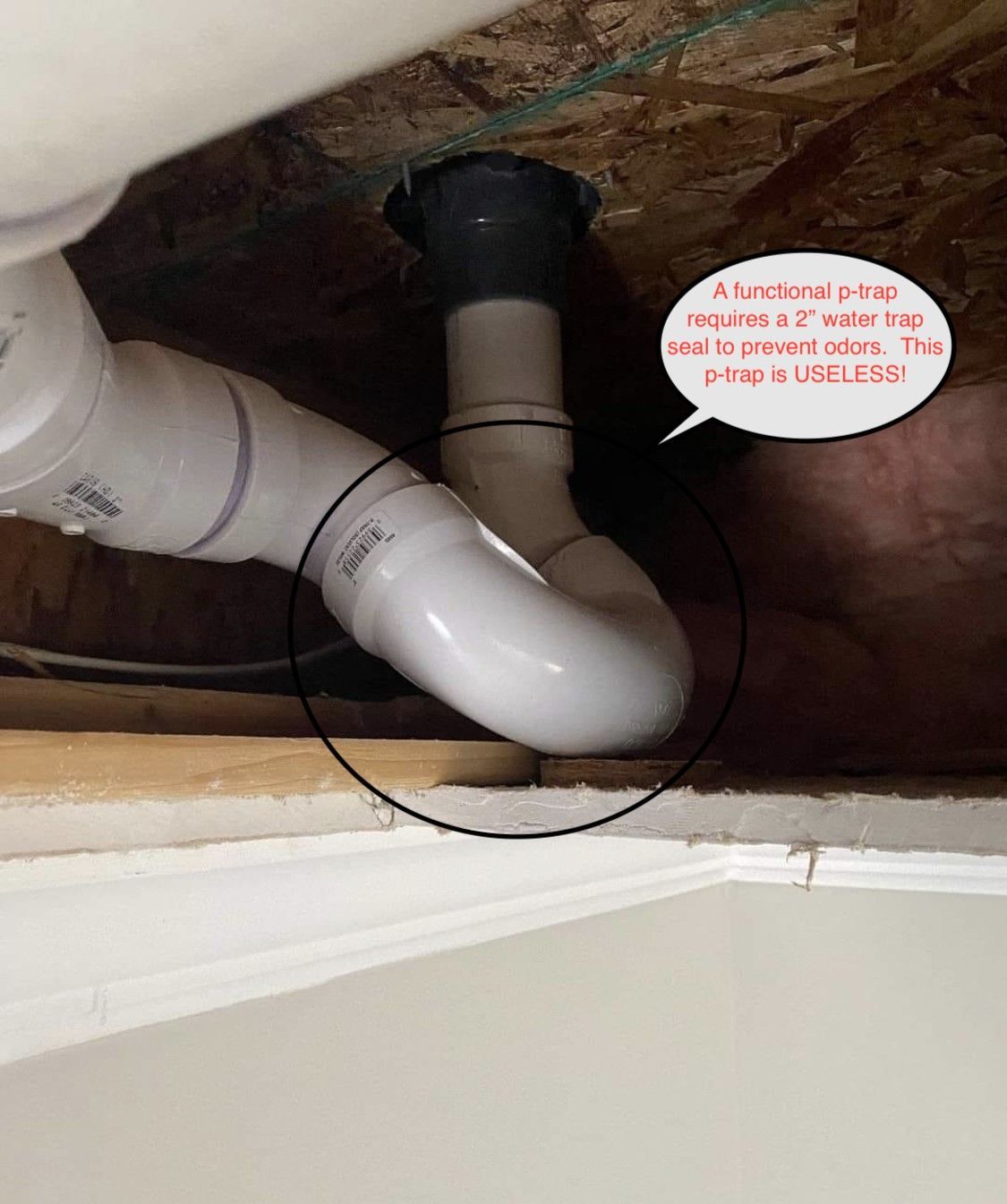 White PVC plumbing trap beneath a sink.