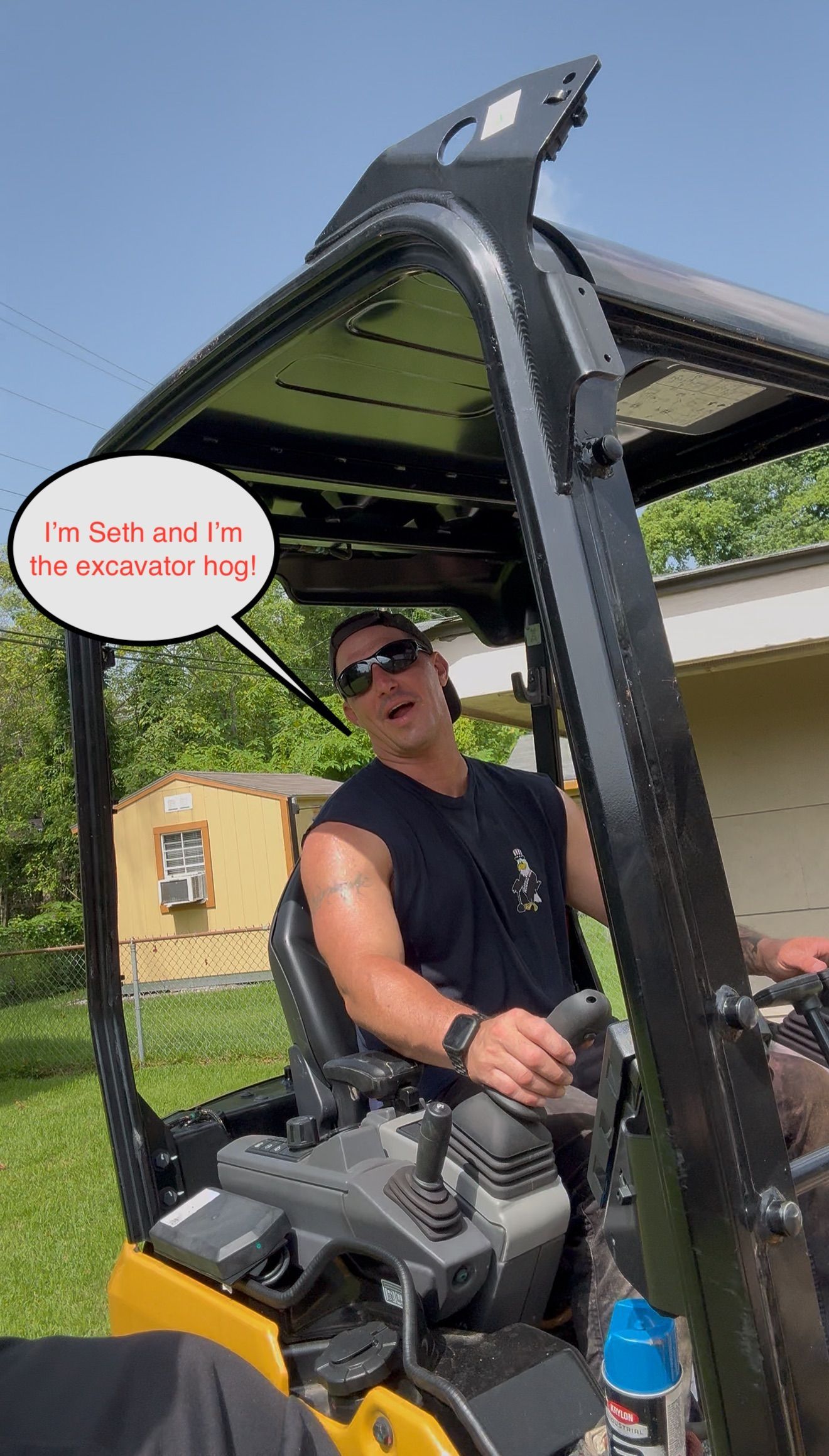 Man in sunglasses operating a yellow construction machine under a canopy, with a speech bubble sign.