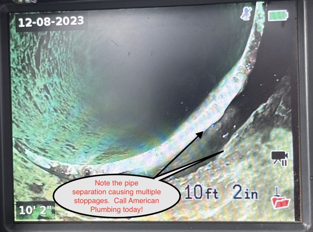 Close-up of a pipe inspection screen showing a damaged pipe interior with crack and distance markers.