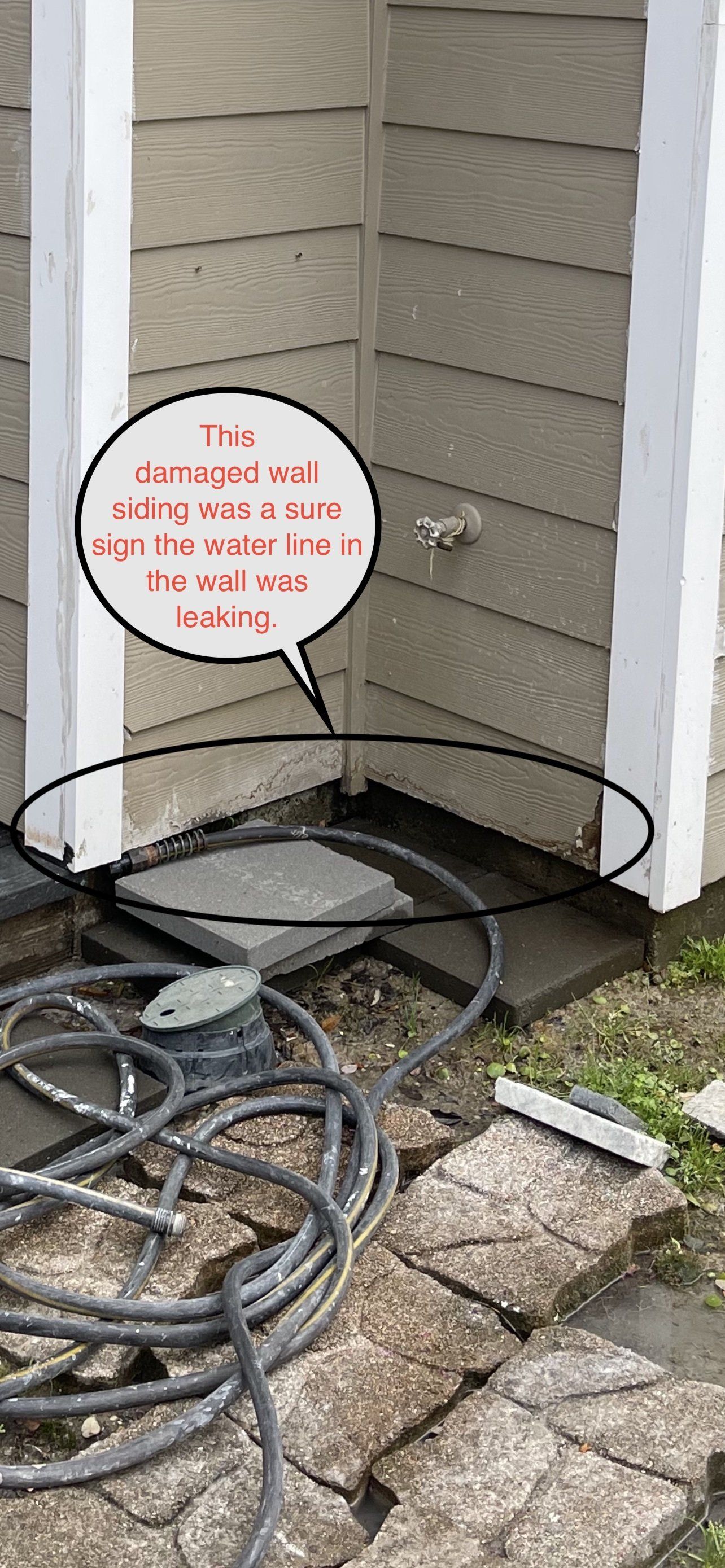 Corner of building with hose, pavers. Text notes: