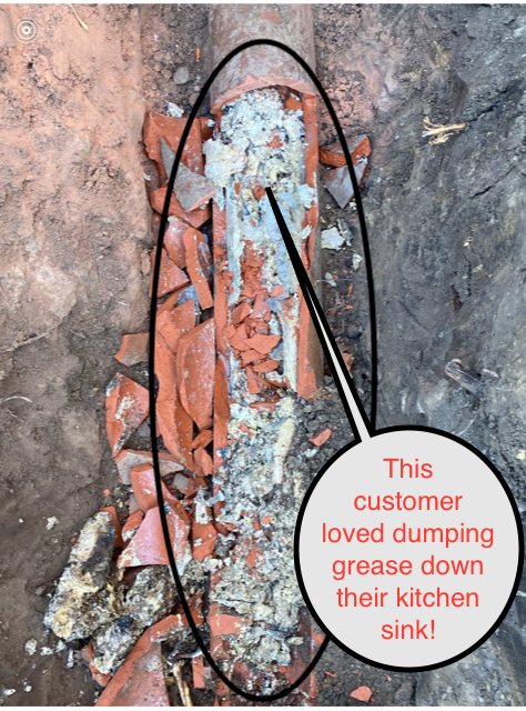 Broken pipe clogged with grease and debris; text labels it was caused by grease dumped down the kitchen sink.