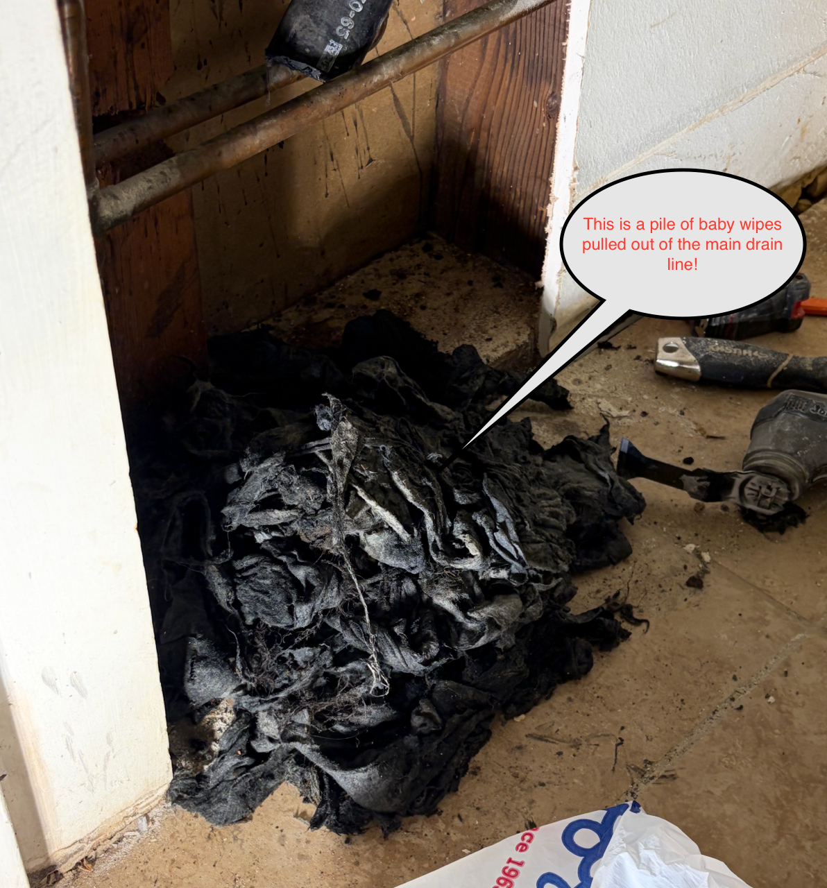 Pile of black debris and dust in a messy corner by a cabinet, with a small speech bubble overlay.