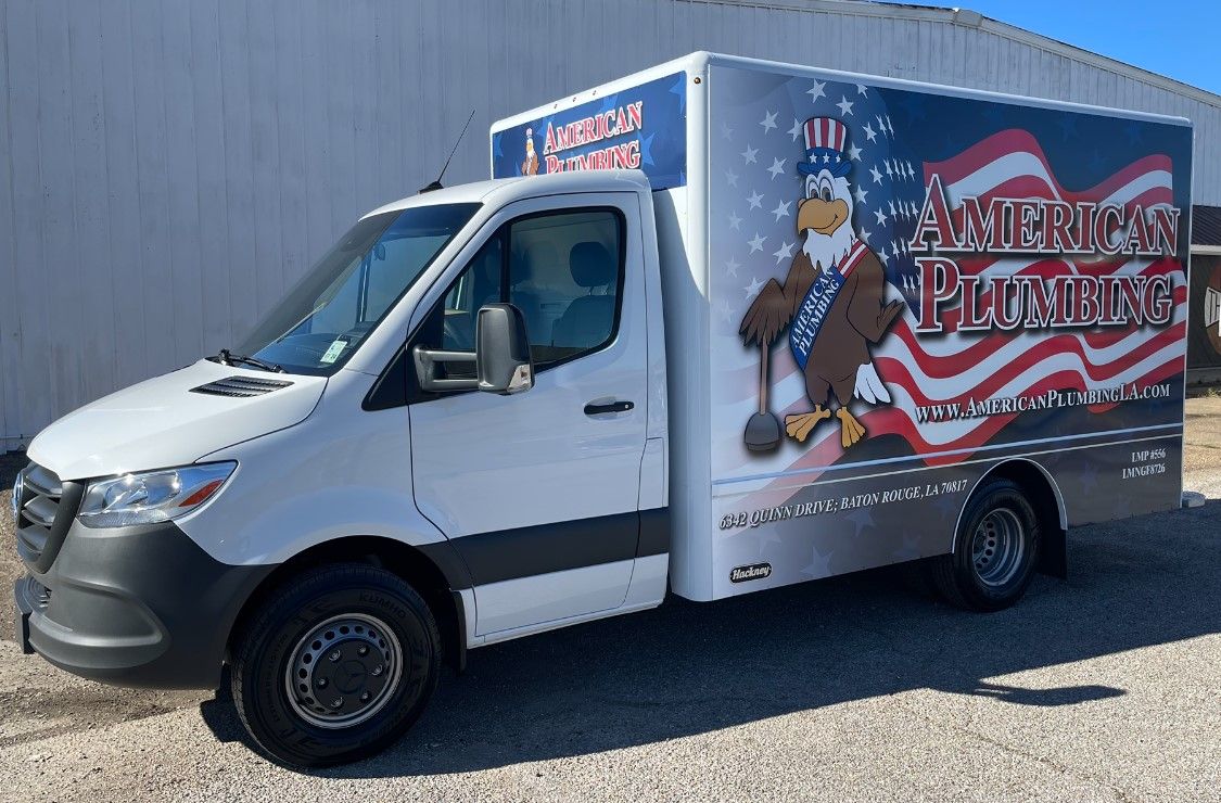 White delivery van with custom patriotic graphics parked on gravel lot.