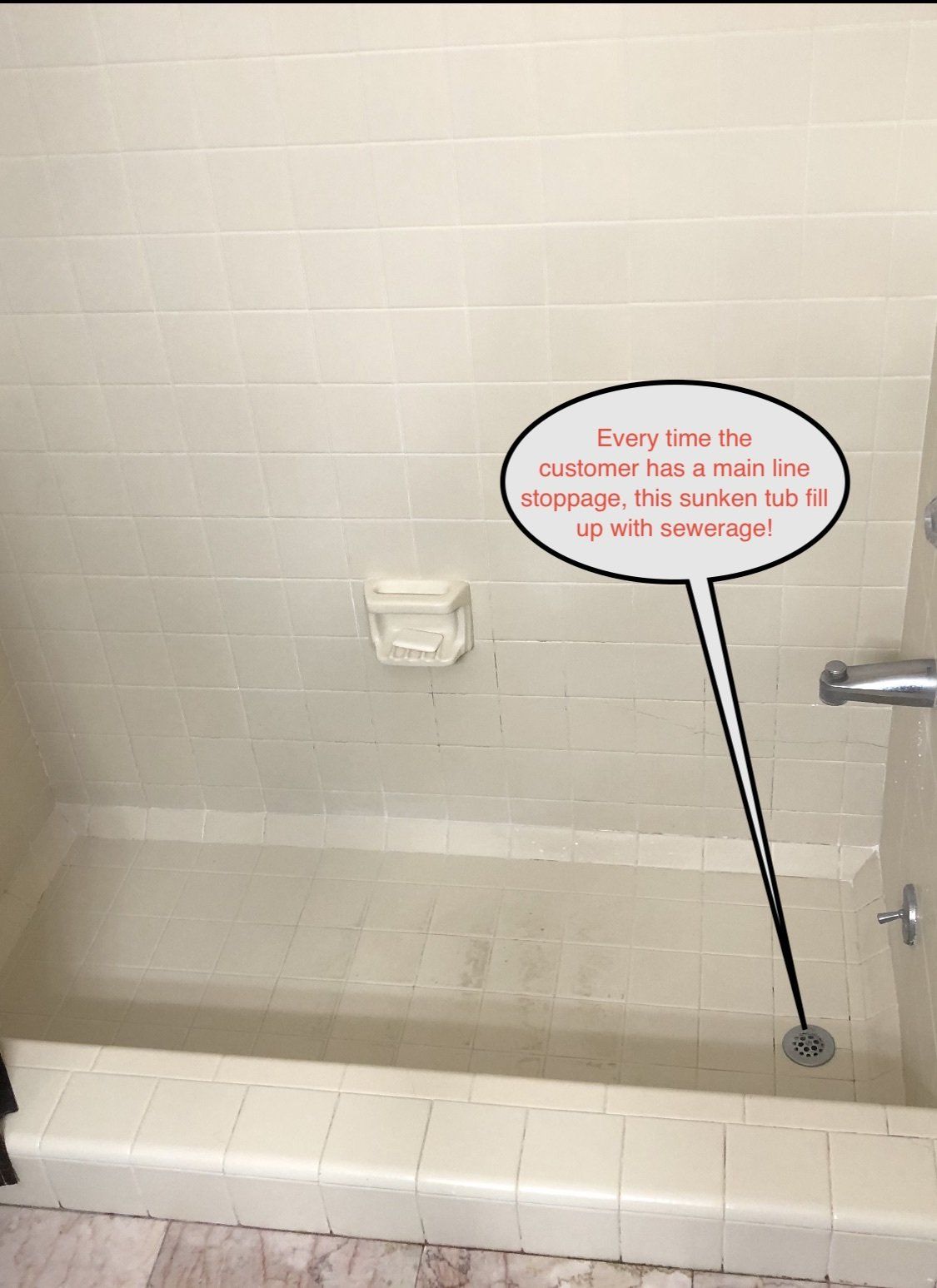 Empty bathtub with white tile walls and a wall sign about water pressure and shower spray.