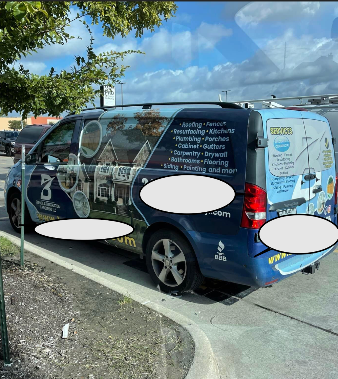 Blue company van parked outdoors with service graphics and a web address on the side.