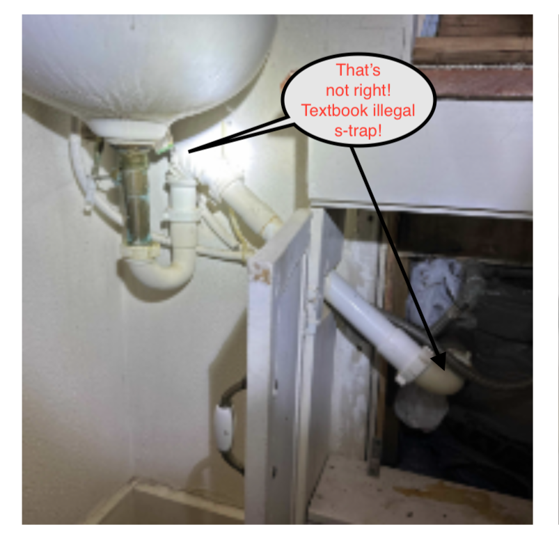 White sink with an improperly installed S-trap plumbing configuration; labeled as